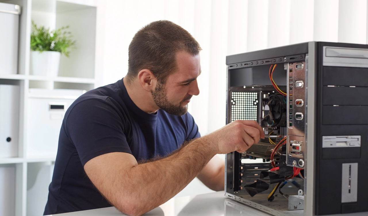 Man repairing a desktop computer.