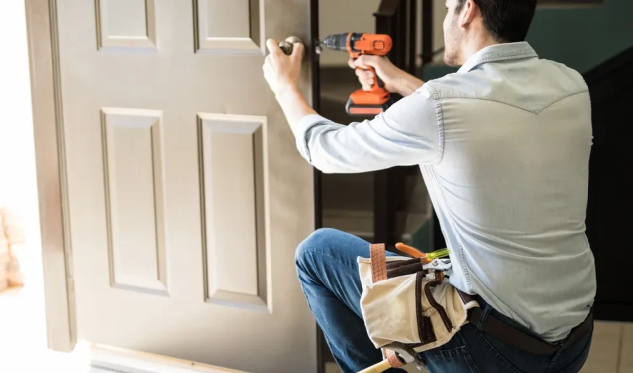 Man installing door with power drill.