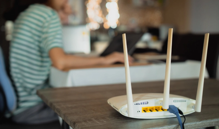 Wi-Fi router on table, person working nearby.